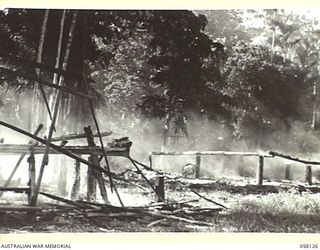 SALAMAUA, NEW GUINEA, 1943-09-26. JAPANESE BUILDINGS ON THE ISTHMUS BURNING FIERCELY AFTER BEING SET ALIGHT BY THE HEAVY ALLIED BOMBARDMENT OF THE AREA