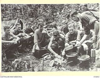 NEW GUINEA. UPPER RAMU VALLEY ADVANCE. 1 NOVEMBER 1943. MESS TIME AT AN ADVANCED POST IN THE UPPER RAMU VALLEY. (NEGATIVE BY G. SHORT)