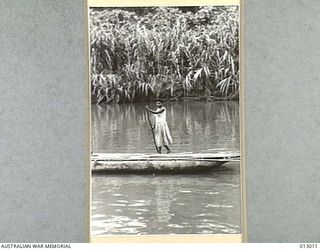 1942-08-06. A NEW GUINEA WOMAN IDLY WENDS HER HOMEWARD WAY. NEW GUINEA. (NEGATIVE BY PARER)