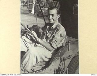 MILNE BAY, NEW GUINEA, 1944-02-10. VX74718 CAPTAIN W.S. BENWELL, AN OFFICER OF THE 8TH FIELD AMBULANCE, AUSTRALIAN ARMY MEDICAL CORPS, PICTURED OUTSIDE THE HEADQUARTERS OF THE MILNE BAY BASE SUB ..