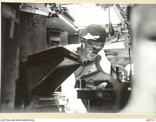 MADANG, NEW GUINEA. 1944-10-12. MAINTENANCE WORK WITHIN THE DRIVER'S COMPARTMENT DURING TANK TESTS CONDUCTED AT HQ 4 ARMOURED BRIGADE