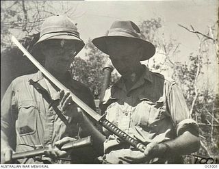 TADJI AIRSTRIP, AITAPE, NORTH EAST NEW GUINEA. 1944-05-02. FLIGHT LIEUTENANT (FL LT) C. R. DAY RAAF, UNLEY PARK, SA, AND FL LT A. R. GREEN, LOCKLEYS, SA, ADMIRE THE BEAUTIFULLY WROUGHT JAPANESE ..