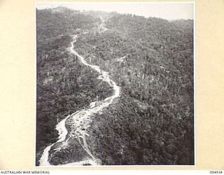 WEWAK AREA, NEW GUINEA. 1945-08-06. THE BIG ROAD VIEWED FROM THE AIRCRAFT CARRYING HEADQUARTERS COMMAND, AUSTRALIAN ARMY SERVICE CORPS, 6 DIVISION, SUPPLIES. IT IS A FINE JOB BY DIVISION ENGINEERS ..