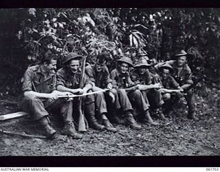 WAREO, NEW GUINEA. 1943-12-09. VX24595 PRIVATE (PTE) H. C. CONGDON OF PEAK HILL, VIC (1) AND FELLOW MEMBERS OF THE 2/23RD AUSTRALIAN INFANTRY BATTALION EXAMINING A JAPANESE SWORD WHICH WAS FOUND IN ..