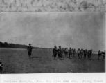 Papua New Guinea, native people carrying supplies along coastline