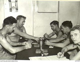 AT SEA. 1944-08/09. MEMBERS OF THE PETTY OFFICER'S MESS ENJOY A GAME OF CRIB IN THEIR QUARTERS ABOARD THE RAN CORVETTE, GEELONG AS THE VESSEL PROCEEDS ALONG THE COAST OF NEW GUINEA