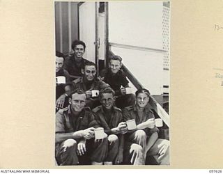 OCEAN ISLAND. 1945-10-02. FOLLOWING THE SURRENDER OF THE JAPANESE TROOPS MEMBERS OF 31/51ST INFANTRY BATTALION OCCUPIED THE ISLAND. SHOWN, MEMBERS OF THE OCCUPATION FORCE DRINKING TEA ON THE STEPS ..