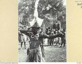 SONG RIVER, FINSCHHAFEN AREA, NEW GUINEA. 1944-03-26. A FINSCHHAFEN BOY DANCING IN A NATIVE SING-SING IN THE AUSTRALIAN NEW GUINEA ADMINISTRATIVE UNIT COMPOUND, HELD TO CELEBRATE RE OCCUPATION OF ..