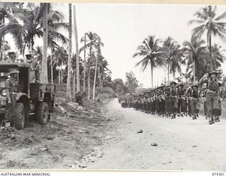 MADANG, NEW GUINEA. 1944-08-15. VX27 MAJOR GENERAL A.H. RAMSAY, CBE, DSO, ED, GENERAL OFFICER COMMANDING 5TH DIVISION, TAKING THE SALUTE FROM MEMBERS OF THE 22ND INFANTRY BATTALION DURING A MARCH ..