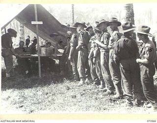 ALEXISHAFEN, NEW GUINEA. 1944-05-27. TROOPS FROM HEADQUARTERS 8TH INFANTRY BRIGADE OUTSIDE A TENT COVERED POLLING BOOTH TO RECORD THEIR VOTES IN THE NEW SOUTH WALES STATE ELECTION. IDENTIFIED ..