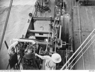 BOERA POINT, NEW GUINEA. 1943-10-01. CABLE WINCH AND OPERATOR ABOARD THE SS MERNOO, MARINE CABLE LAYING SHIP