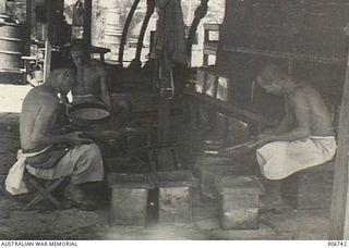 Three Japanese prisoners from the RAN War Criminal Compound at the RAN shore base, sifting rice before preparing a meal. Work on this RAN base commenced in August 1948. It was commissioned as HMAS ..