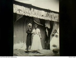 Soputa, New Guinea, 1943. Cast members of the 36th Battalion, Australian Military Forces (AMF), concert party dressed in costume as female impersonators on a temporary stage of an outdoor theatre. ..