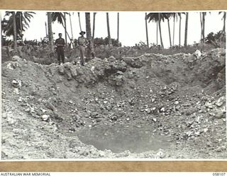 FINSCHHAFEN, NEW GUINEA, 1943-10-02. A HUGE BOMB CRATER MADE BY A HEAVY ALLIED AIRCRAFT BOMB