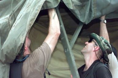 US Air Force Major Greg Perkinson and US Air Force Technical Sergeant Mike McMullan both of the 36th Civil Engineer Squadron, Andersen Air Force Base, Guam, raise up a tent to house airmen from the 96th Bomb Squadron and support personnel from the 2nd Bomb Wing, Barksdale Air Force base, Louisiana. The airmen are deployed to Naval Station Diego Garcia in support of Operation DESERT THUNDER 2