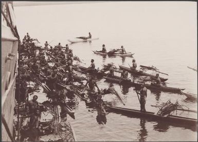 Solomon Islanders in canoes trading with passengers on the Southern Cross, Santa Cruz Islands, 1906 / J.W. Beattie