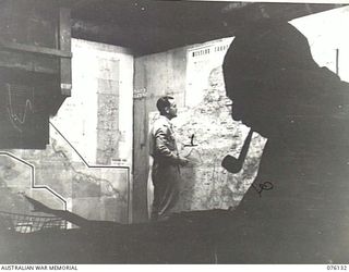 LAE, NEW GUINEA. 1944-09-12. VX81110 LIEUTENANT H.J. FORD (1), AND QX50075 CAPTAIN L. RICHARDS (2), AT WORK IN THE BATTLE ROOM, HEADQUARTERS NEW GUINEA FORCE