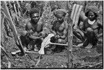 Ritual exchange: men measure strand of cowrie shells against blade of stone axe