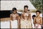 Man in grass skirt and boys