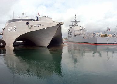 A starboard bow view of the US Navy (USN) High Speed Vessel Two (HSV 2) SWIFT (foreground), conducting mooring operations opposite to the US Navy (USN) Ticonderoga Class Guided Missile Cruiser (Aegis) USS LAKE ERIE (CG 70), during a brief port visit at Naval Base Pearl Harbor, Hawaii (HI), prior to deploying to Southeast Asia to provide assistance to victims of the devastating Tsunami that hit the region in support of Operation UNIFIED ASSISTANCE