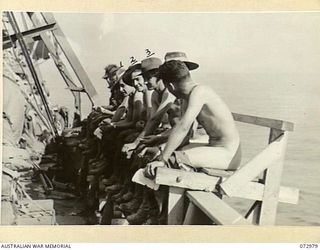 The sanitary arrangements used by members of the 5th division during the 21 hour journey to Saidor aboard the American liberty ship David E. Hughes. Identified are Private Harrison (third from ..