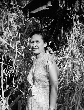 [Portrait of Pacific Island woman in front of dense vegetation]