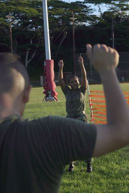 US Marine Corps (USMC) Sergeant (SGT) Savage (facing camera), Headquarters and Service Battalion (H&S BN), Marine Forces Pacific (MARFORPAC), Camp H. M. Smith, Hawaii (HI), leads calisthenics, while participating in a unit wide conditioning exercise to enhance their combat readiness and improve their personal physical fitness