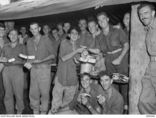 RABAUL, NEW BRITAIN, 1945-12-25. OFFICERS SERVING CHRISTMAS DINNER TO THE TROOPS OF 2/4TH ARMOURED REGIMENT