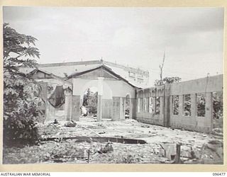 RABAUL, NEW BRITAIN, 1945-09-11. ALL BUILDINGS AND INSTALLATIONS AT RABAUL WERE DESTROYED DURING ALLIED AIR ATTACKS. THIS PHOTOGRAPH SHOWS THE REMAINS OF THE NEW GUINEA CLUB AS SEEN BY MEMBERS OF ..