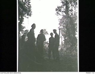 THE SOLOMON ISLANDS, 1945-04-24/27. FOUR AUSTRALIAN SOLDIERS STAND QUIETLY AS TWO RNZAF CORSAIR AIRCRAFT PASS OVERHEAD ON BOUGAINVILLE ISLAND. (RNZAF OFFICIAL PHOTOGRAPH.)