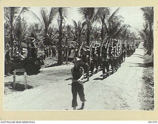 JACQUINOT BAY, NEW BRITAIN. 1945-04-21. BRIGADIER C.R.V. EDGAR, COMMANDER 4 INFANTRY BRIGADE (1), TAKES THE SALUTE FROM B COMPANY, 37/52 INFANTRY BATTALION DURING THE MARCH PAST