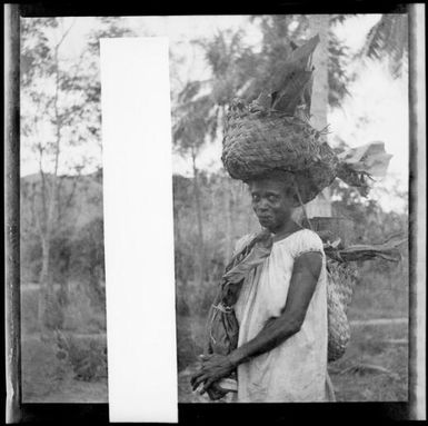 Woman carrying a bag on her head walking to the Boong, native markets, Rabaul, New Guinea, ca. 1936 / Sarah Chinnery