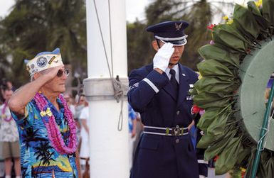 World War II (WWII) Veteran Mr. Byram Bates (left), and US Air Force (USAF) SENIOR AIRMAN (SRA) John Y.H. Kim, a member of the Hickam AFB, Hawaii (HI) Honor Guard Team, pay respects to fallen soldiers during a Flagpole Ceremony held to commemorate the attack on Hickam Field during the WWII Japanese invasion