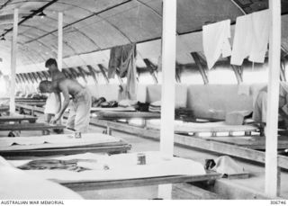 Beer and other comforts provided by the International Red Cross, Tokyo are placed on the beds of Japanese prisoners held at the RAN War Criminal Compound at an RAN shore base. Work on this RAN base ..