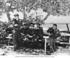 Group from the Bikini Atoll Radiological Survey taking a break in the shade with USS CHILTON in background, summer 1947