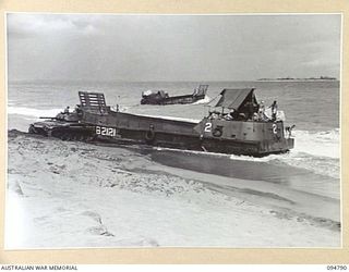 TOROKINA AREA, BOUGAINVILLE, 1945-08-06. AN M24 GENERAL CHAFFEE LIGHT TANK ATTEMPTING TO FLOAT THE STRANDED AUSTRALIAN LANDING CRAFT 40 WITH THE ASSISTANCE OF A TOW ROPE FROM ANOTHER BARGE. THE ..