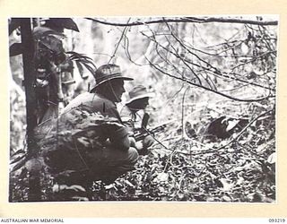 WEWAK AREA, NEW GUINEA, 1945-06-16. CAPT H.A. COULSTON, OFFICER COMMANDING B COMPANY, 2/8 INFANTRY BATTALION (1), GIVING INSTRUCTIONS TO PTE W.J. SMITH, BREN GUNNER (2) WHO IS PLACED ACROSS THE ..