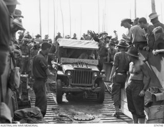 ALEXISHAFEN, NEW GUINEA. 1944. A JEEP OF THE 84TH AUSTRALIAN MOBILE CINEMA MOVING ABOARD THE COURIER BARGE OF THE 593RD UNITED STATES BARGE COMPANY IN PREPARATION FOR THE RETURN TRIP TO MADANG