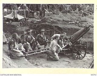 SORAKEN, BOUGAINVILLE. 1945-06-02. THE CREW OF NO. 4 GUN, 2 MOUNTAIN BATTERY AT THE READY. IDENTIFIED PERSONNEL ARE:- SERGEANT A.R. DAVIS (1); BOMBARDIER I. CROTHERS (2); GUNNER L.V. WEDLICK (3); ..