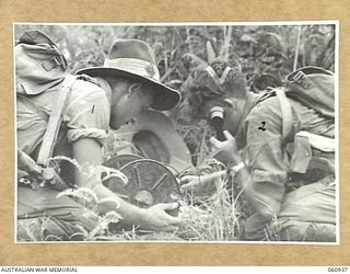 DONADABU AREA, NEW GUINEA. 1943-11-30. VX40500 BOMBARDIER STRIPP (LEFT) AND VX17507 GUNNER TILLY (RIGHT) BOTH OF THE 2/4TH AUSTRALIAN FIELD REGIMENT, OPERATING SIGNALLING EQUIPMENT DURING COMBINED ..