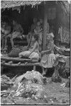 Mortuary ceremony: people at exchange, piles of taro, banana leaf bundles and fiber skirts (wealth items) in foreground