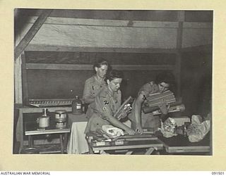 LAE, NEW GUINEA. 1945-05-07. AUSTRALIAN WOMEN'S ARMY SERVICE PERSONNEL UNPACKING REGIMENTAL AID POST STORES IN THE NEWLY CONSTRUCTED AWAS BARRACKS IN BUTIBUM ROAD. THE AWAS ARE MEMBERS OF A GROUP ..