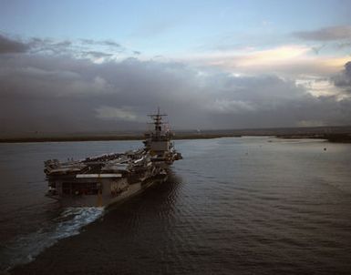 Aerial starboard quarter view of the nuclear-powered aircraft carrier USS ENTERPRISE (CVN 65) as it enters Pearl Harbor. Members of the crew man the rail