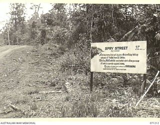 FINSCHHAFEN AREA, NEW GUINEA, 1944-03-17. ONE OF MANY BATTLE SIGNS IN THE FINSCHHAFEN AREA, THIS SIGN AT SPRY STREET RECORDS ACTIVITIES OF THE 2/23RD INFANTRY BATTALION ASSISTED BY THE 13TH FIELD ..