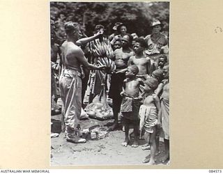 LABU, NEW GUINEA. 1944-12-17. 43 LANDING CRAFT COMPANY PERSONNEL AMONG NATIVES TRADING THEIR BISCUITS AND TINNED MEAT FOR FRUIT