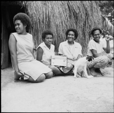 Four Fijian women listening to their radio in front of a house, Fiji, 1966 / Michael Terry