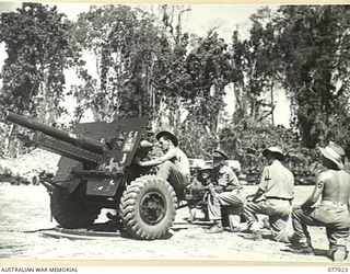 BOUGAINVILLE ISLAND, 1944-11-17. OFFICERS OF THE 4TH FIELD REGIMENT, UNDERGOING A REFRESHER COURSE IN 25 POUNDER GUN DRILL. IDENTIFIED PERSONNEL ARE:- VX927 LIEUTENANT L.R. BESTEL (1); VX108061 ..