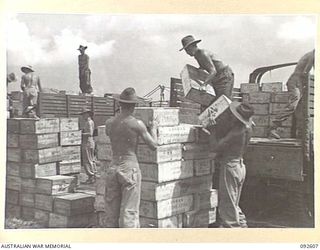 CAPE WOM, NEW GUINEA, 1945-05-29. TROOPS UNLOADING SUPPLIES FROM A TRUCK AT ONE OF THE DUMPS AT THE FIELD MAINTENANCE CENTRE