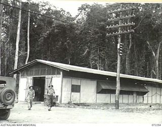 LAE, NEW GUINEA. 1944-04-03. MEMBERS OF THE 19TH LINES OF COMMUNICATION SIGNALS OUTSIDE THE LAE CARRIER TERMINAL HUT WHICH JOINS THE JUNGLE TELEGRAPH LINE BETWEEN LAE AND PORT MORESBY