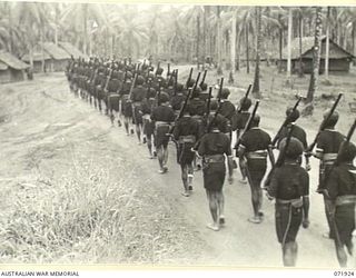 MILNE BAY, PAPUA, NEW GUINEA. 1944-04-01. MEMBERS OF THE ROYAL PAPUAN CONSTABULARY IN THE SAMARAI DISTRICT MARCHING WITH RIFLES AT THE SLOPE DURING A PARADE